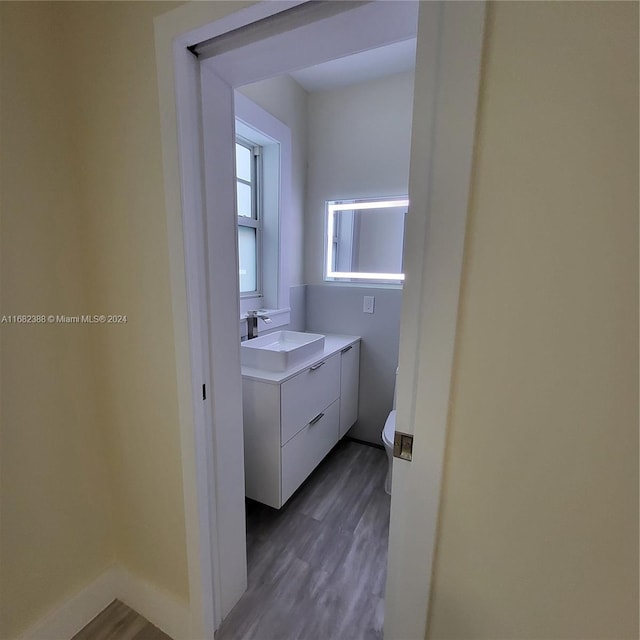 bathroom with vanity, toilet, and wood-type flooring