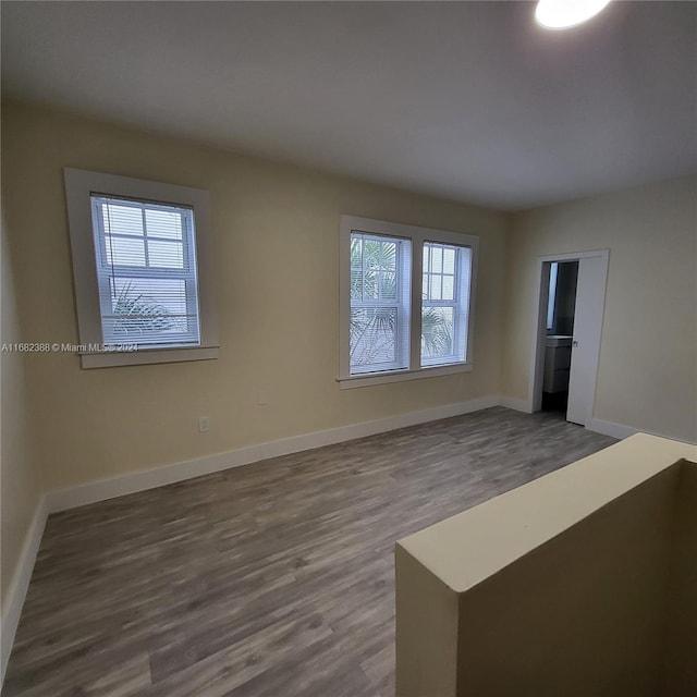 empty room with dark hardwood / wood-style floors and a wealth of natural light