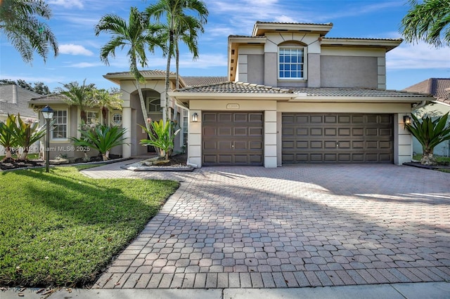 mediterranean / spanish house with a front lawn and a garage