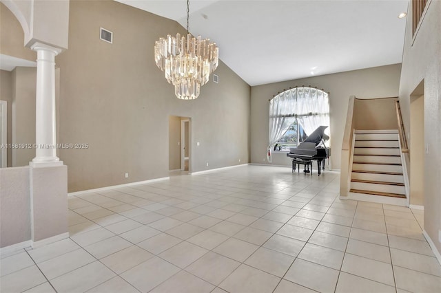 empty room with ornate columns, a towering ceiling, light tile patterned floors, and an inviting chandelier