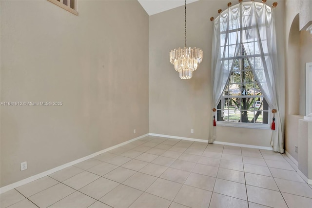 tiled empty room with a notable chandelier