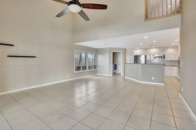 unfurnished living room with ceiling fan and light tile patterned flooring