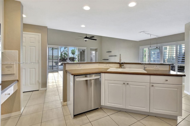 kitchen with sink, pendant lighting, dishwasher, white cabinetry, and light tile patterned flooring