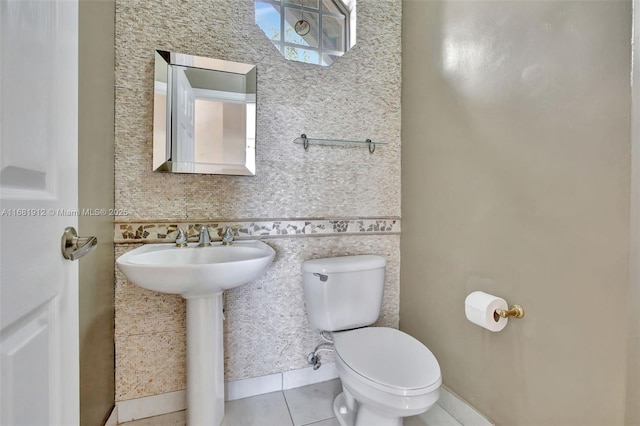 bathroom with toilet, tile patterned floors, and sink