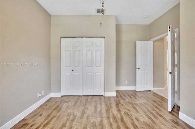 unfurnished bedroom with light hardwood / wood-style floors and a closet