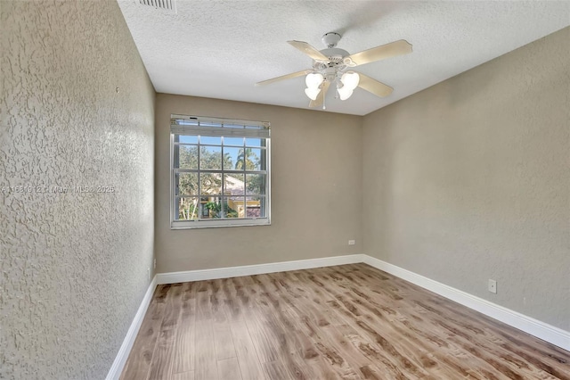 unfurnished room featuring ceiling fan, wood-type flooring, and a textured ceiling