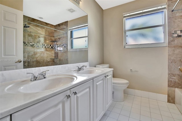 bathroom with a tile shower, tile patterned flooring, vanity, and toilet