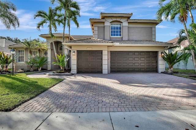 mediterranean / spanish house featuring a front yard and a garage