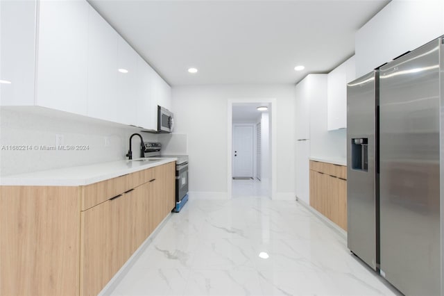 kitchen with white cabinetry, stainless steel appliances, and sink