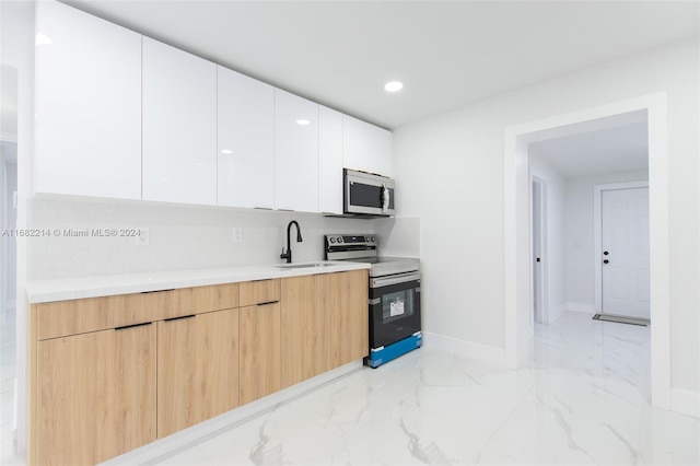 kitchen featuring white cabinetry, light brown cabinetry, appliances with stainless steel finishes, and sink