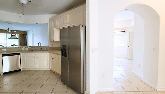 kitchen featuring white cabinetry, sink, light tile patterned flooring, and stainless steel appliances