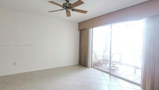 tiled spare room featuring ceiling fan