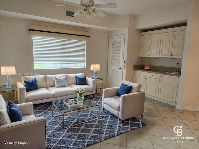 tiled living room featuring ceiling fan and sink