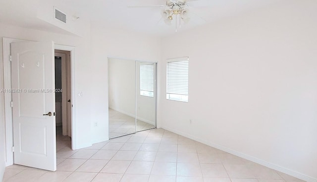 unfurnished bedroom featuring ceiling fan, light tile patterned floors, and a closet