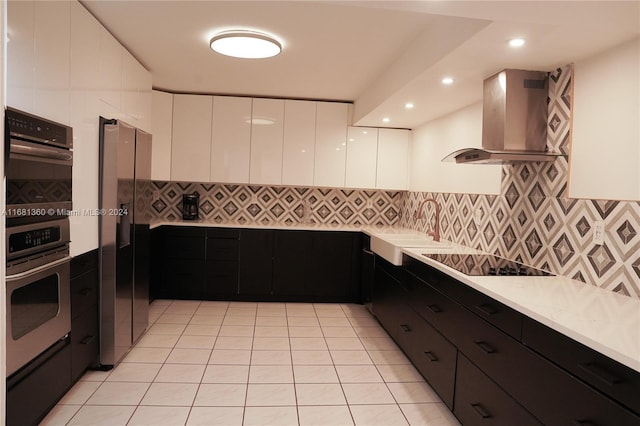 kitchen featuring sink, stainless steel appliances, white cabinets, extractor fan, and light tile patterned floors