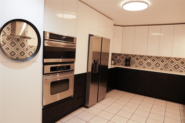 kitchen featuring appliances with stainless steel finishes, white cabinetry, and tasteful backsplash