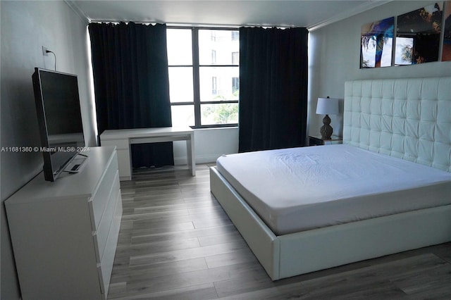 bedroom with crown molding and hardwood / wood-style floors