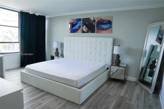 bedroom featuring crown molding and light wood-type flooring