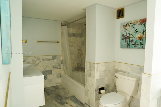 full bathroom featuring toilet, shower / bath combo with shower curtain, vanity, and tile walls