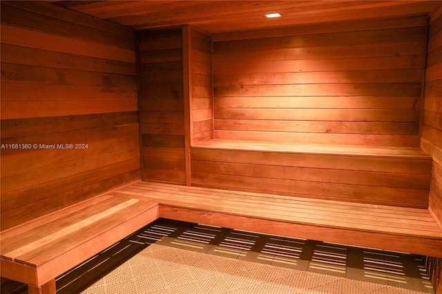 view of sauna featuring wood ceiling and wooden walls