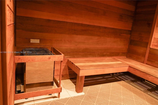 view of sauna featuring tile patterned floors and wooden walls