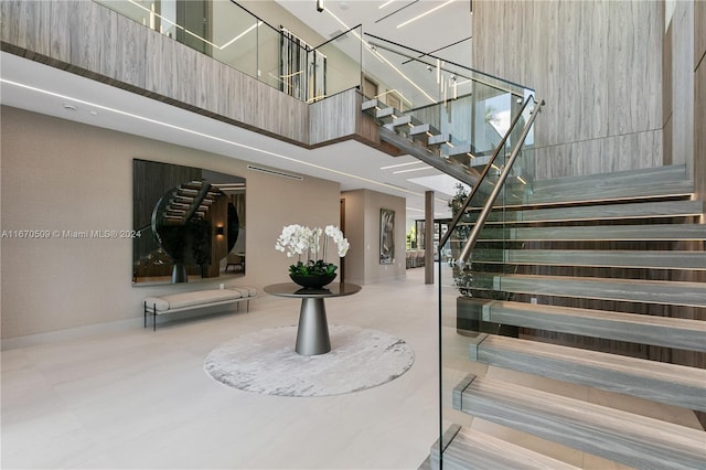 stairway featuring a towering ceiling