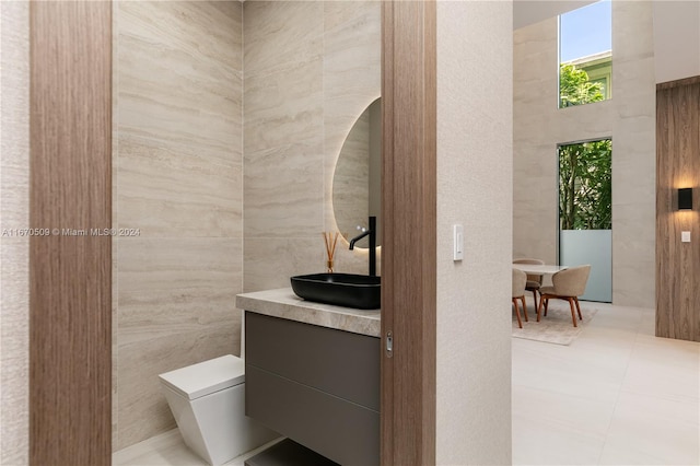 bathroom featuring tile walls, tile patterned flooring, vanity, and toilet