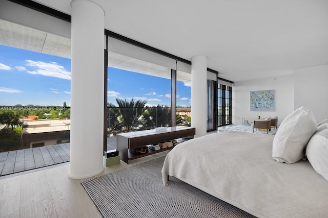 bedroom featuring a wall of windows and hardwood / wood-style flooring