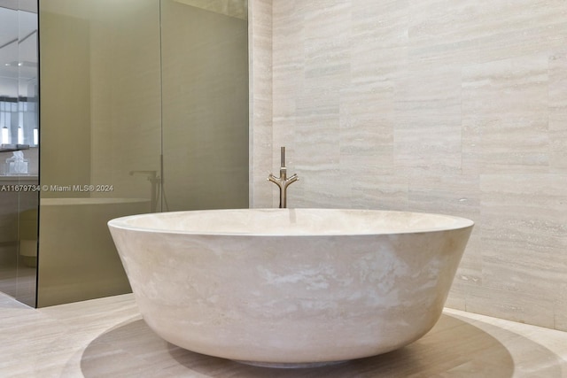 bathroom with tile walls and a tub