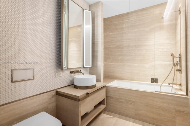 full bathroom featuring tile patterned floors, vanity, tile walls, toilet, and tiled shower / bath