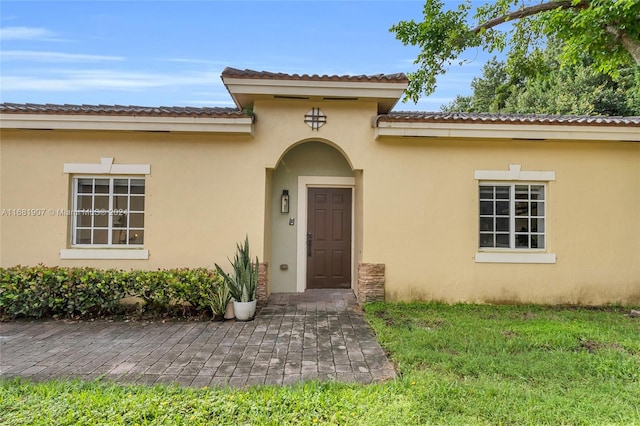 entrance to property featuring a lawn