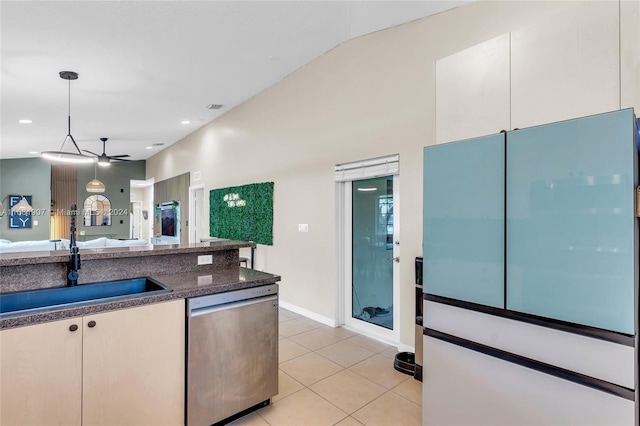 kitchen featuring white cabinets, light tile patterned floors, stainless steel dishwasher, sink, and decorative light fixtures