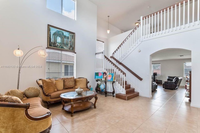 living room with light tile patterned flooring and a high ceiling