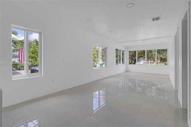 tiled empty room featuring a healthy amount of sunlight