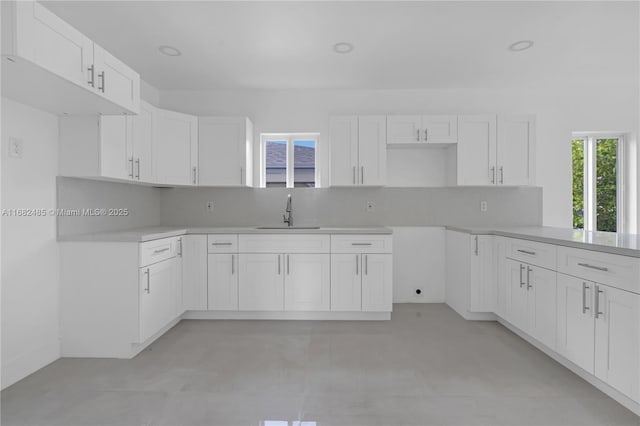 kitchen featuring white cabinets, backsplash, and sink