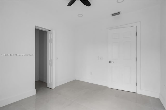 tiled empty room with ceiling fan