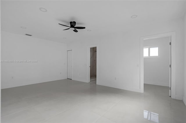 empty room with ceiling fan and light tile patterned flooring