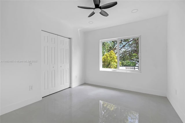 unfurnished bedroom with ceiling fan and a closet