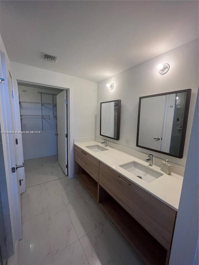 full bathroom with double vanity, visible vents, a sink, and marble finish floor