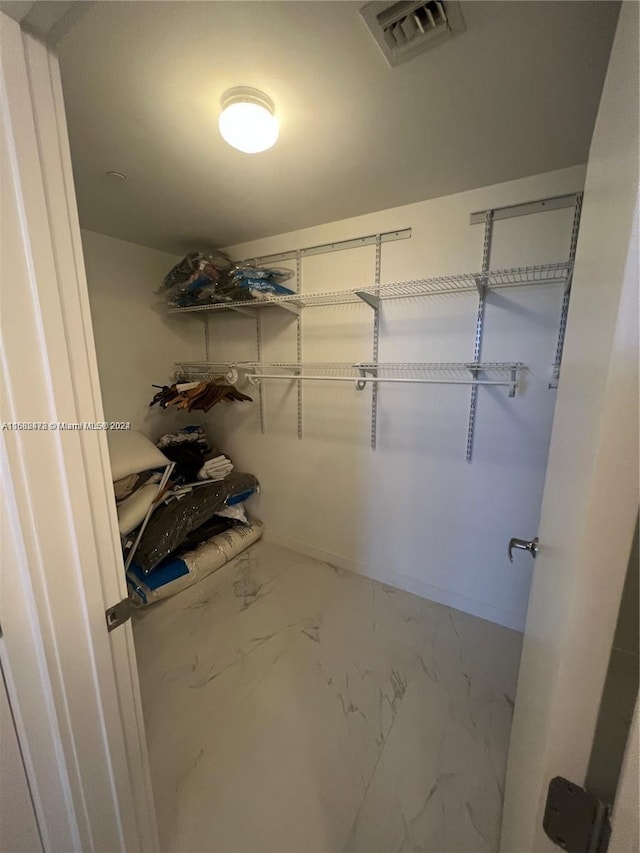 spacious closet with marble finish floor and visible vents