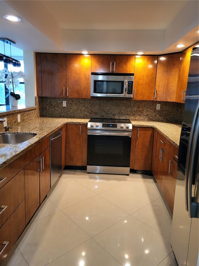 kitchen featuring light stone counters, stainless steel appliances, sink, and light tile patterned floors