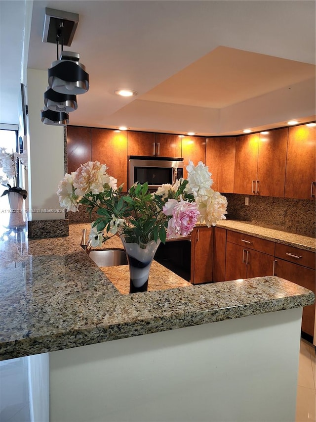 kitchen featuring decorative backsplash, light stone countertops, and light tile patterned floors