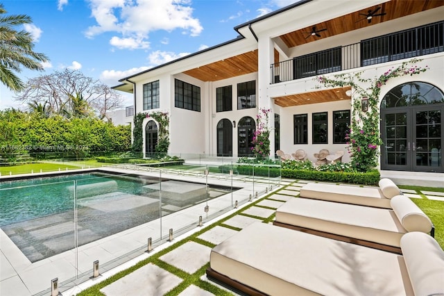 406 Tamarind Dr, Hallandale Beach, FL 33009 - back of house with french doors, a balcony, an outdoor pool, a ceiling fan, and stucco siding