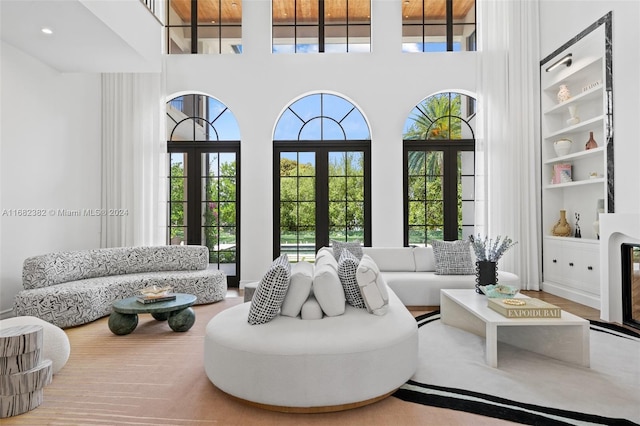 living room with a towering ceiling, french doors, and built in shelves