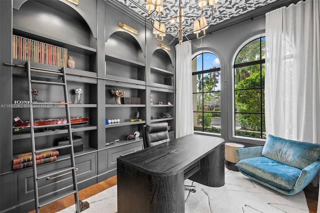 office area featuring built in features, wood-type flooring, ornamental molding, and a chandelier