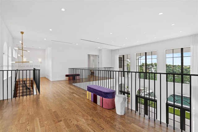 hall featuring light hardwood / wood-style flooring and a notable chandelier