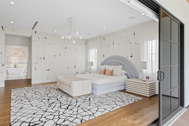 bedroom with hardwood / wood-style floors and a notable chandelier