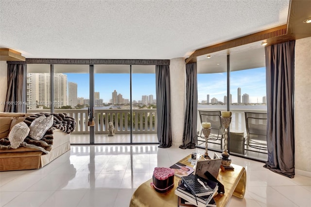 tiled living room featuring a textured ceiling and floor to ceiling windows