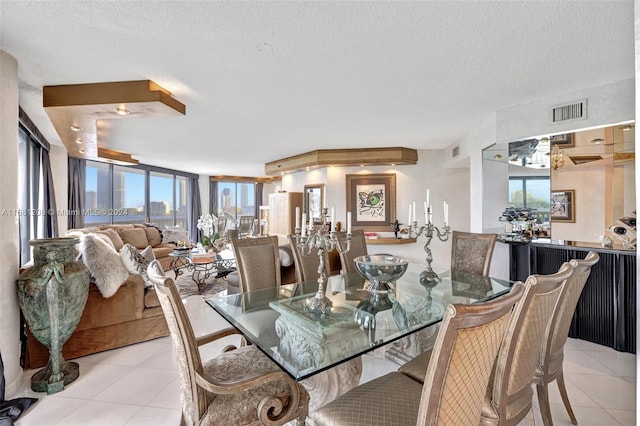 dining area with light tile patterned flooring, a textured ceiling, and a healthy amount of sunlight