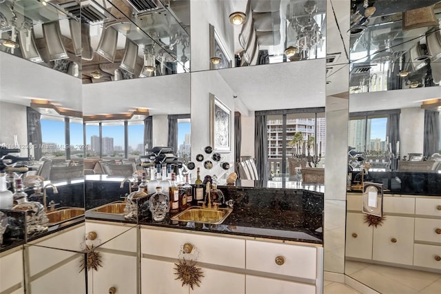 kitchen with a towering ceiling, white cabinetry, light tile patterned floors, and plenty of natural light